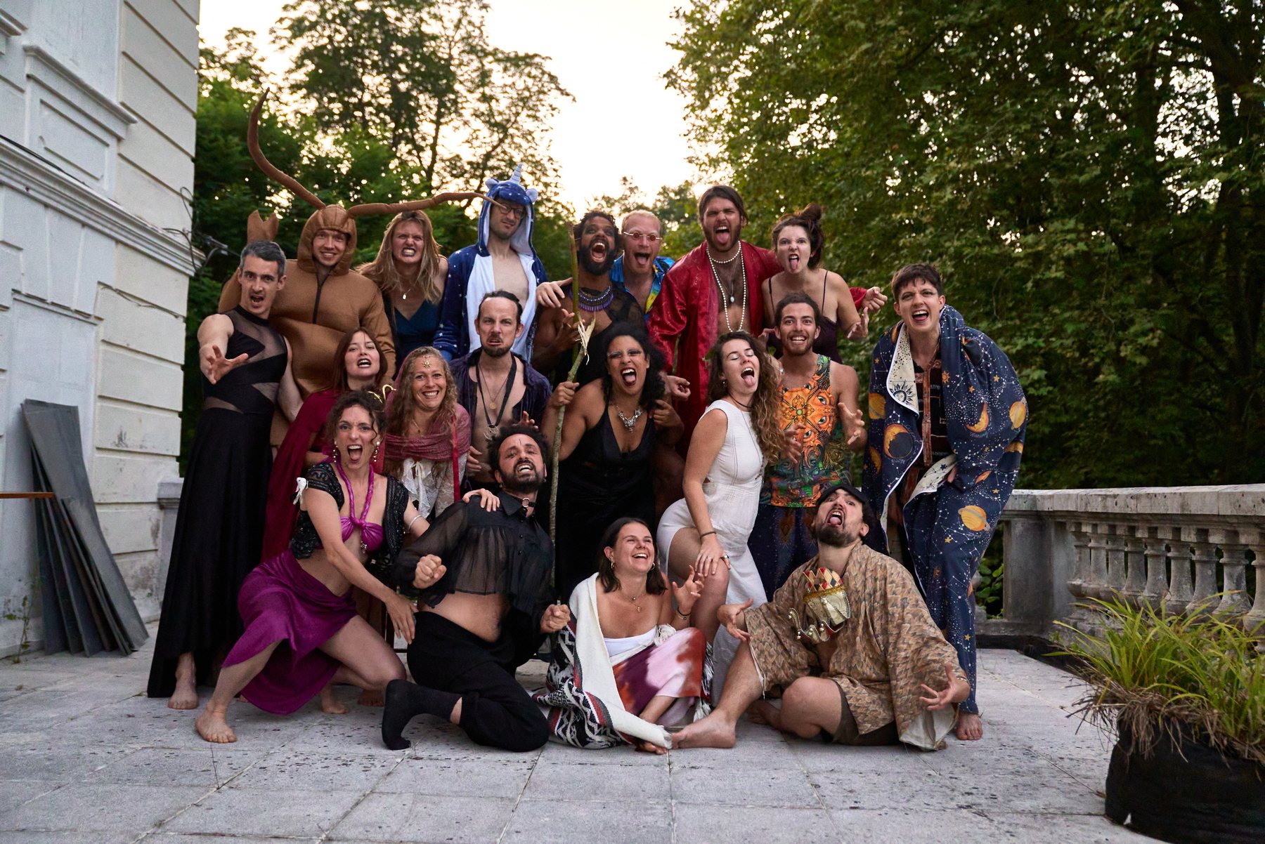 Photo de groupe costumée des 23 participant·es sur le perron de la maison lors de la crémaillère