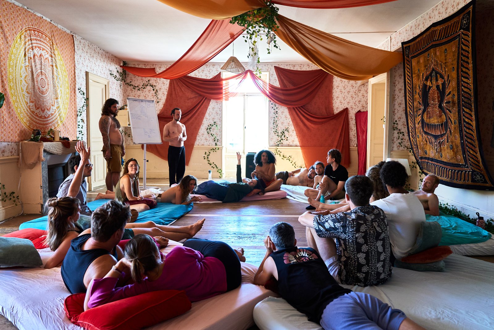 Un cercle de participant·es assis en tailleur dans la salle de pratique de Terres de Ciel pendant un stage