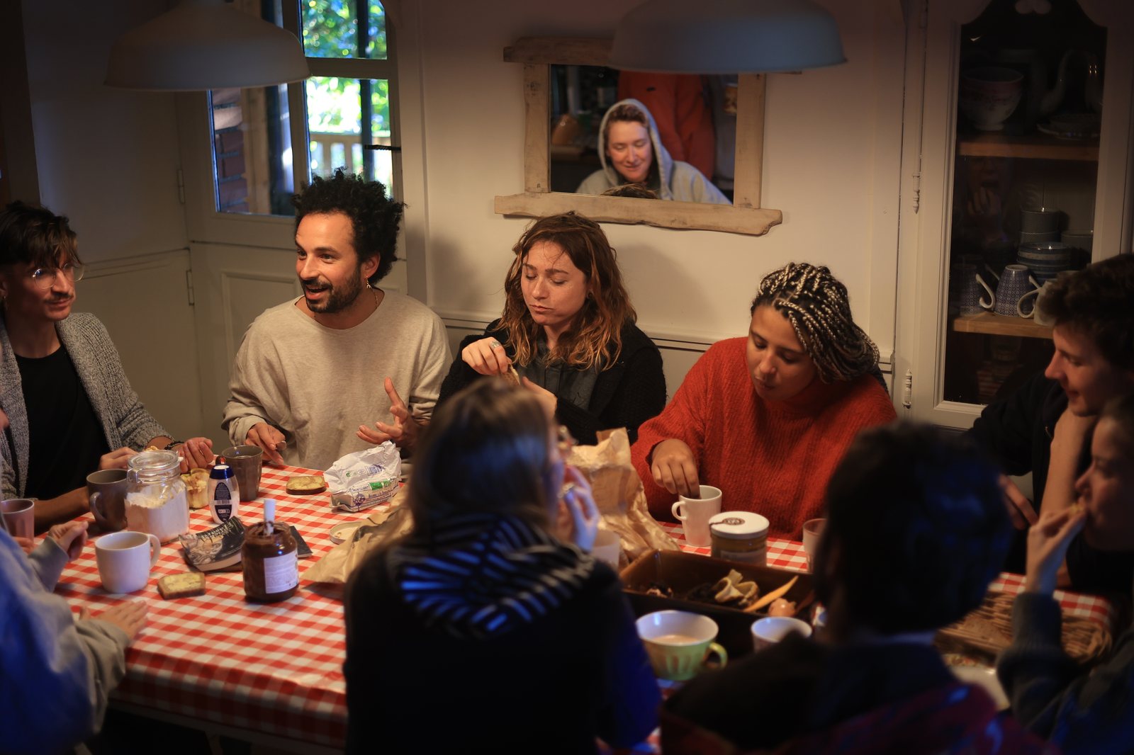 Le collectif et des participant·es partageant un repas autour de la grande table de la maison