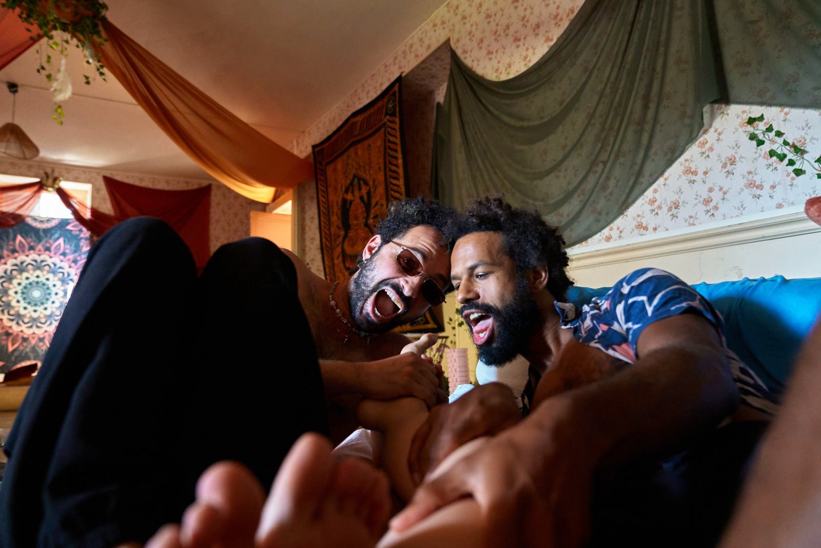 Deux participants complices et rieurs allongés dans la salle de pratique de Terres de Ciel