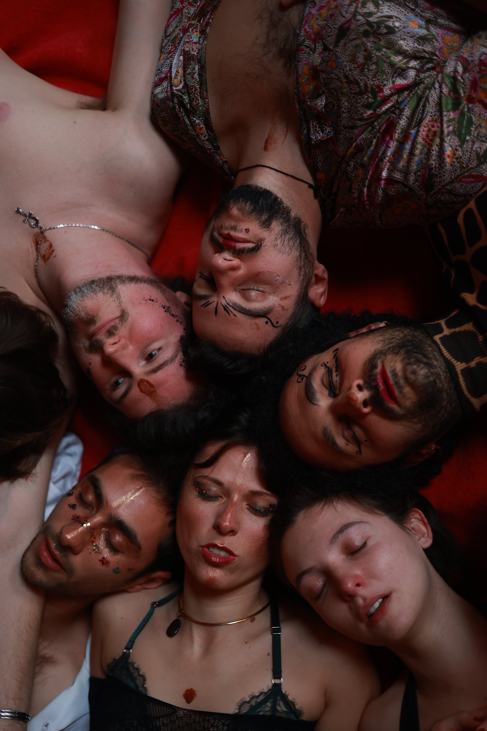 Les participant·es des Retrouvailles, visages collés et yeux fermés, allongé·es en cercle